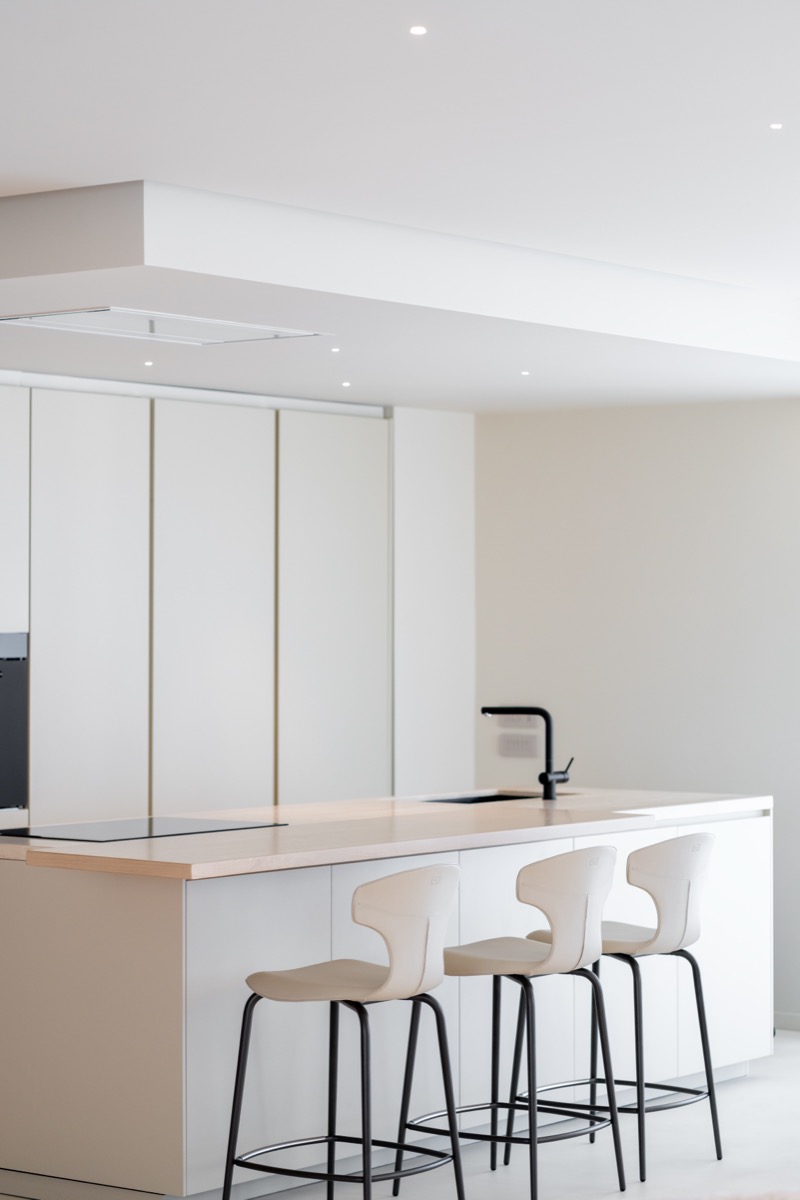 cucina a isola poliform chiara nel living di un attico con dettagli in travertino