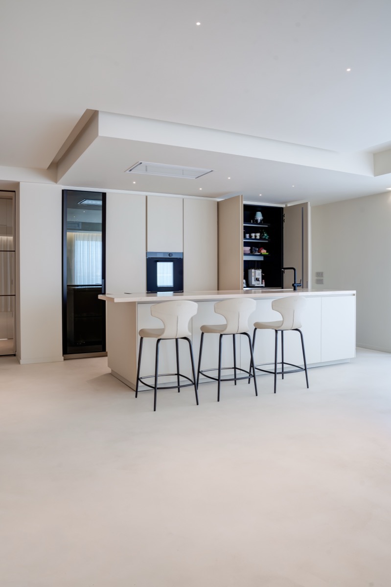 cucina a isola poliform chiara nel living di un attico con dettagli in travertino