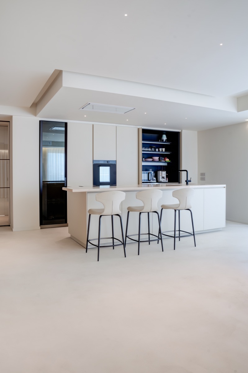 cucina a isola poliform chiara nel living di un attico con dettagli in travertino