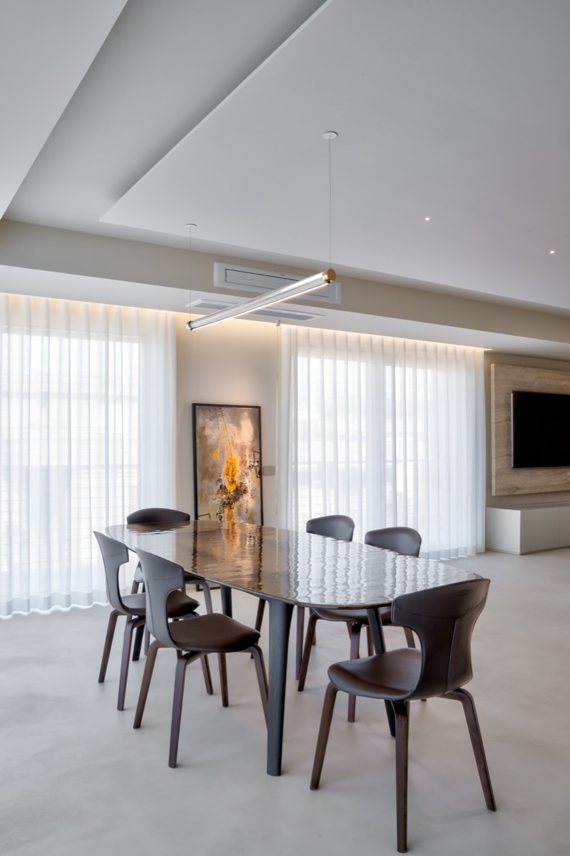 sala da pranzo con tavolo fiam e sedie frau nel living di una casa con eleganti finiture in travertino