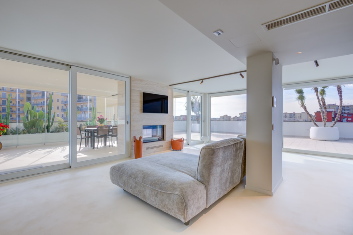 il secondo soggiorno con divano Edra e la veranda con camino bifacciale in travertino