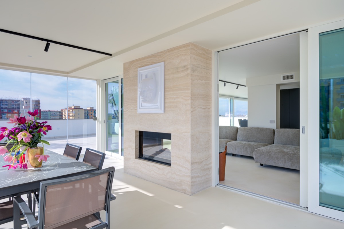 il secondo soggiorno con divano Edra e la veranda con camino bifacciale in travertino