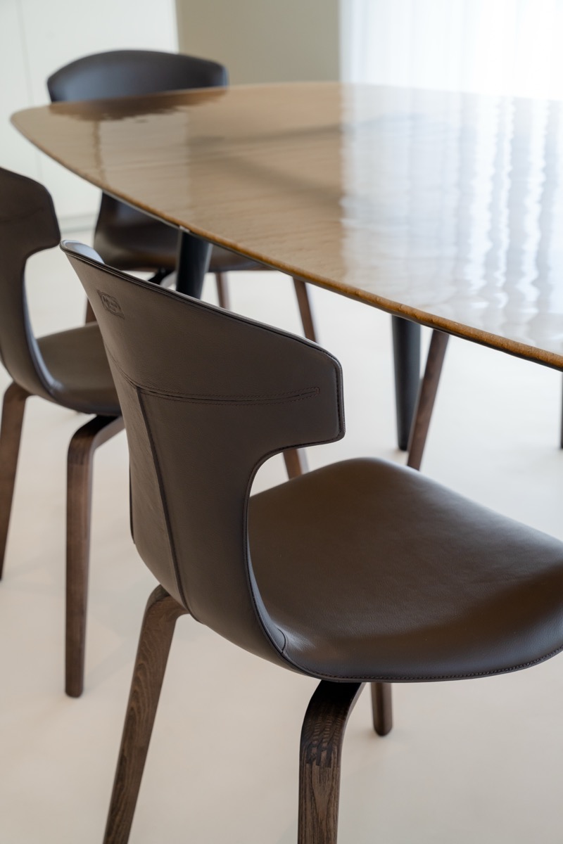 sala da pranzo con tavolo fiam e sedie frau nel living di una casa con eleganti finiture in travertino