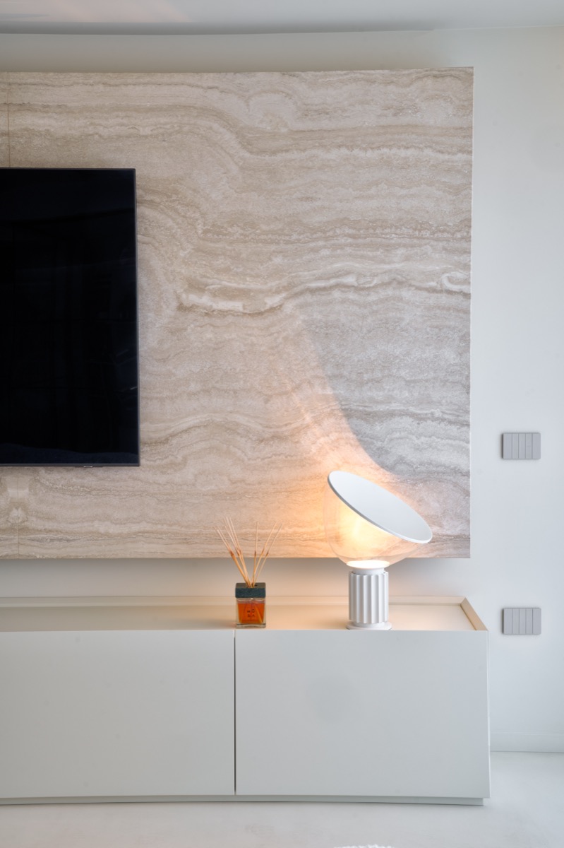 parete tv con boiserie in travertino e lampada taccia small bianca