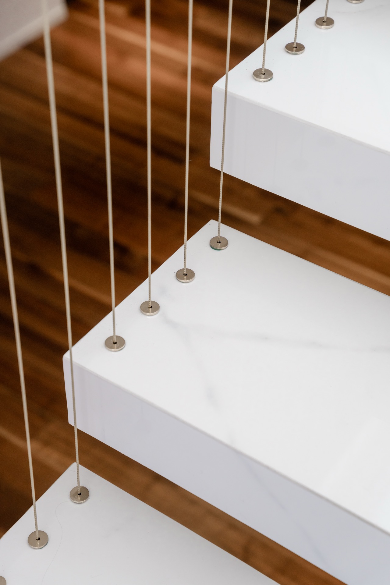 dettaglio dei tiranti sui gradini della scala su disegno. Al piano superiore il living open-space