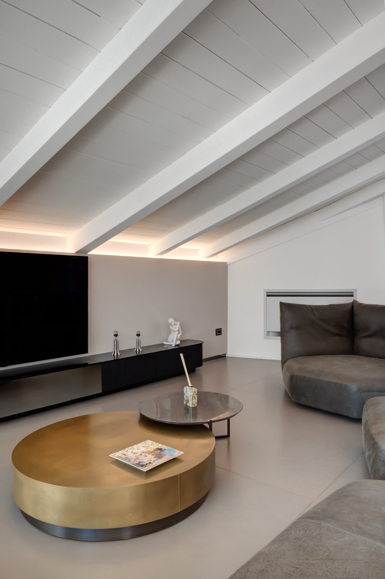 angolo tv del living open-space con tavolini da caffe rotondi baxter loren e icaro stone