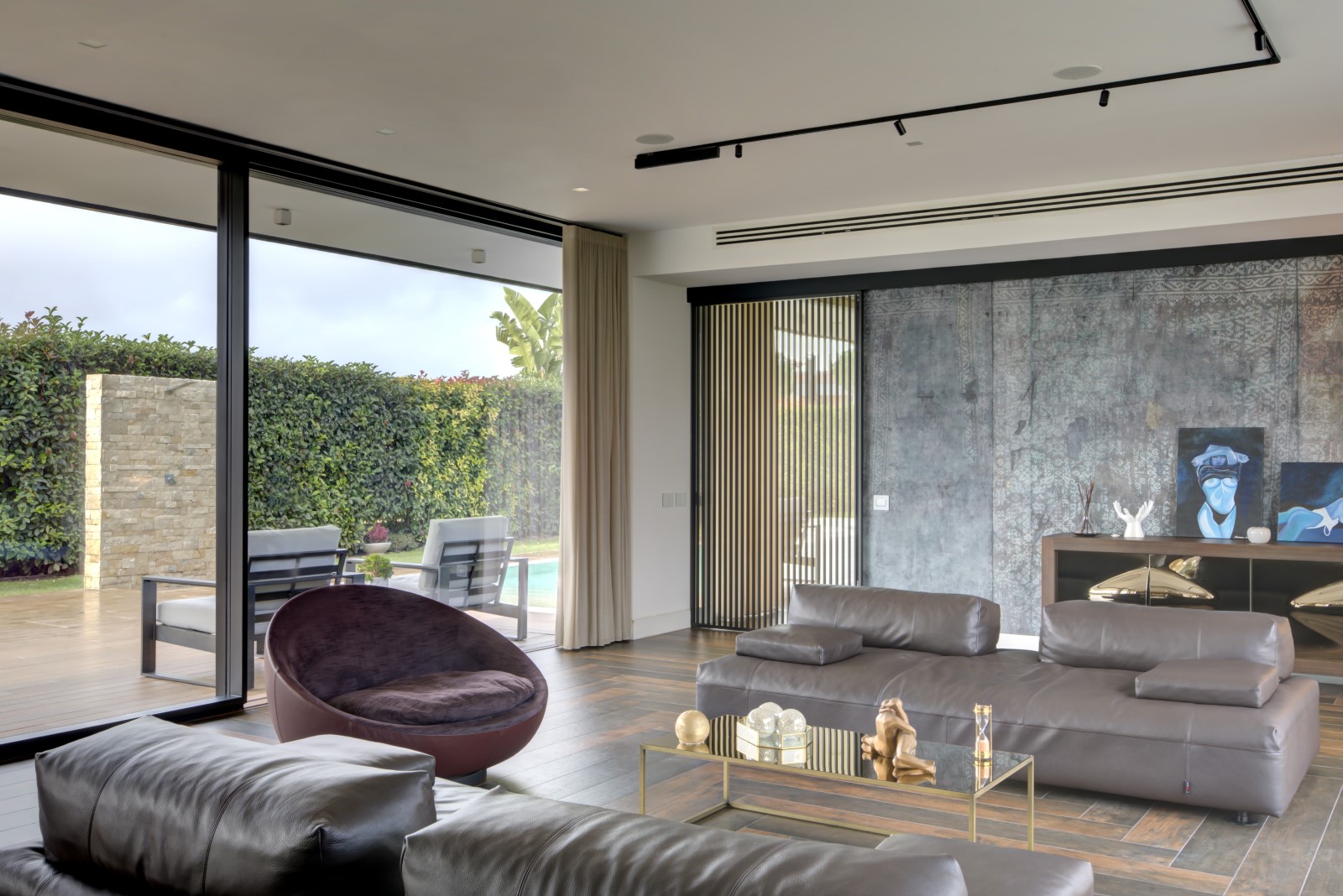 Zona living con divani modulari e poltrona girevole Desirée Divani Monopoli e poltrona Lacoon Desirée in soggiorno moderno